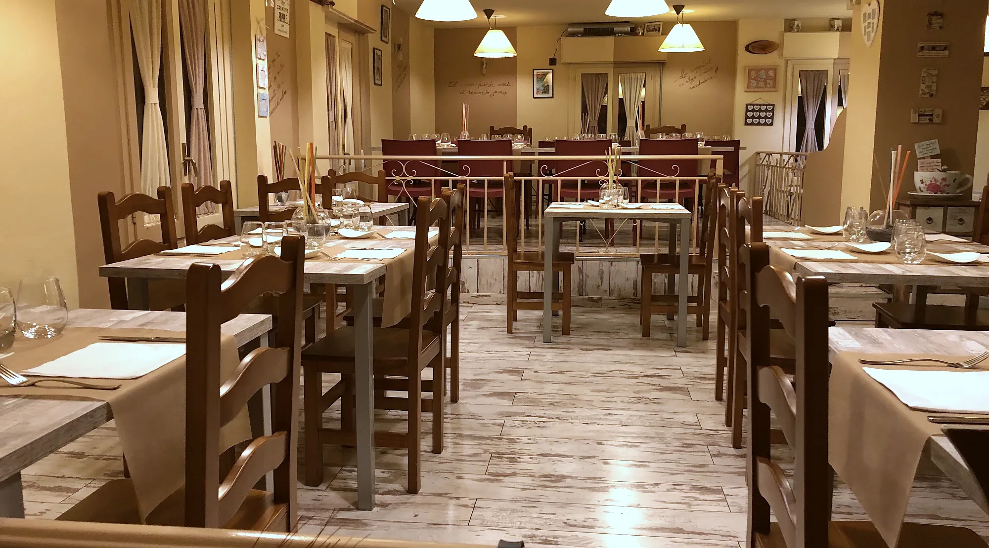 Comedor de El Redebal en Segovia, con mesas vestidas y frases escritas en las paredes