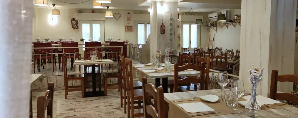 Sala de El Redebal con las mesas preparadas y la escalera al comedor de arriba